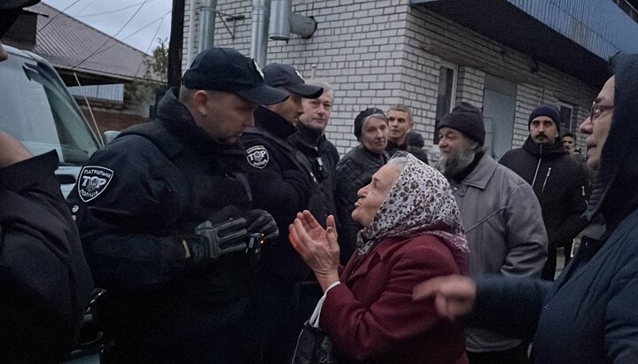 A UOC believer and police officers near the monastery of the Nativity of the Theotokos (UOC) in Cherkasy. Photo: spzh.news