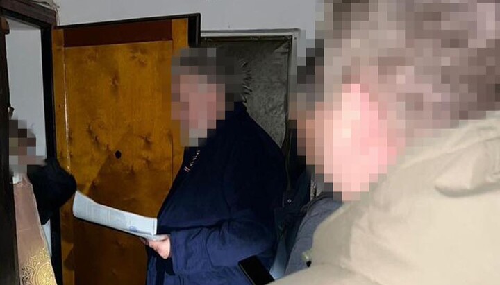 The SBU official is presenting a suspicion notice to a UOC priest. Photo: SBU