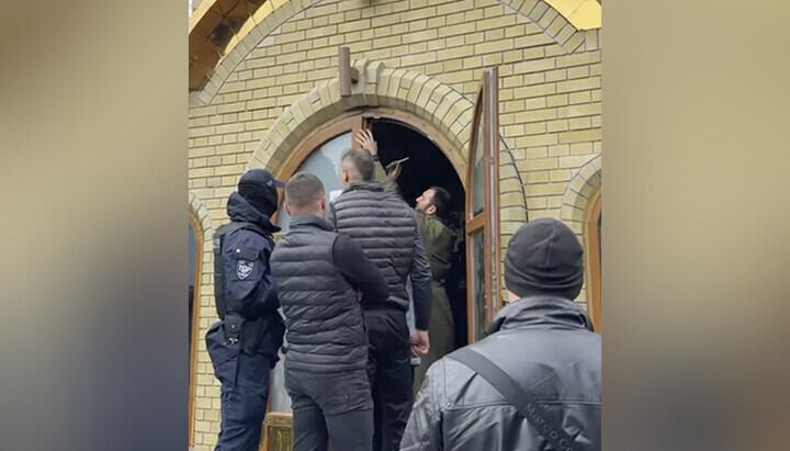 Клирик ПЦУ Засански проваљује врата Андрејевског храма у Черкасима. Фото: СПН