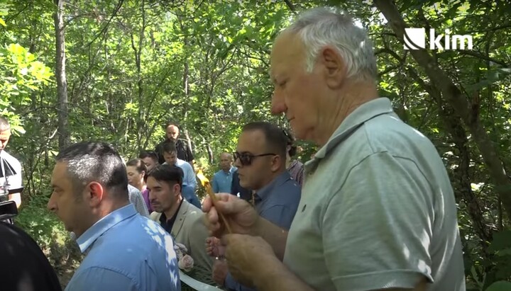 Живорад Симић, син убијеног Трајана, стоји са свећама за време парастоса. Фото: скриншот ЈТ видеа