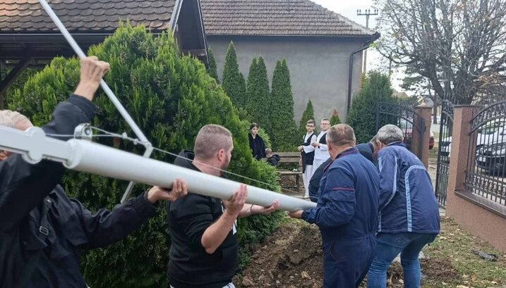Верници с радницима постављају јарболе у црквеној порти Храма Рођења Светог Јована Претече у Босуту. Фото: Епархија сремска/јереј Никола Лакић